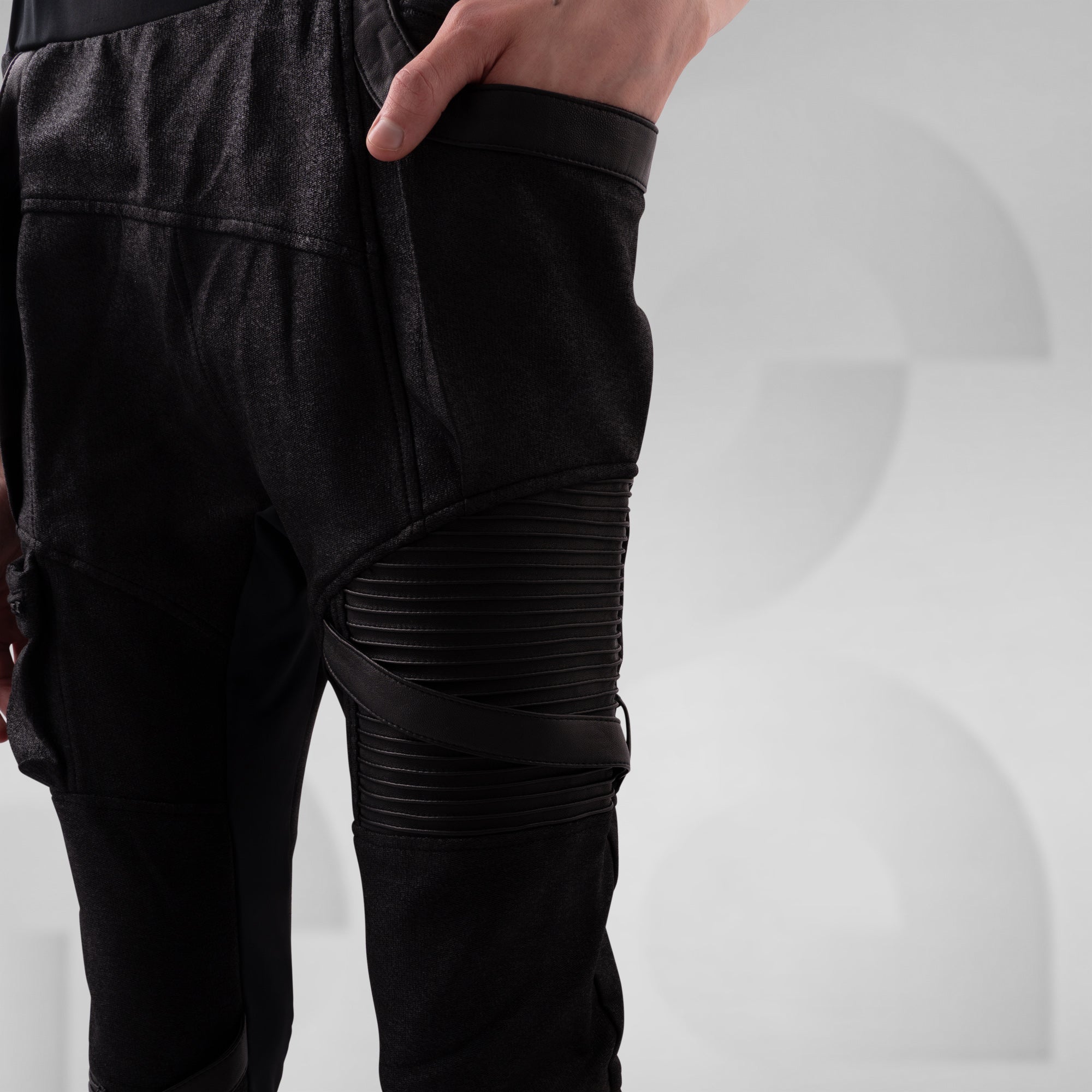 Black pants with leather accents on a white background