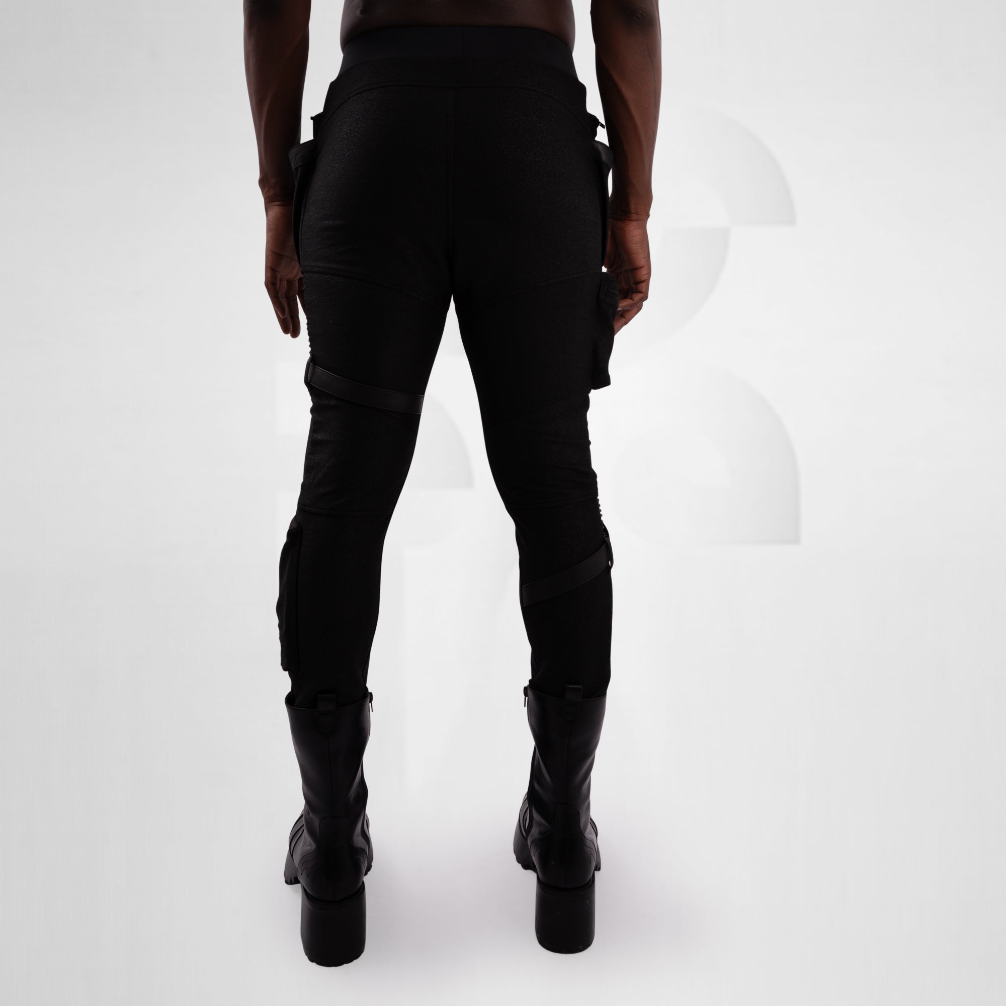 Person wearing black pants and boots on a white background