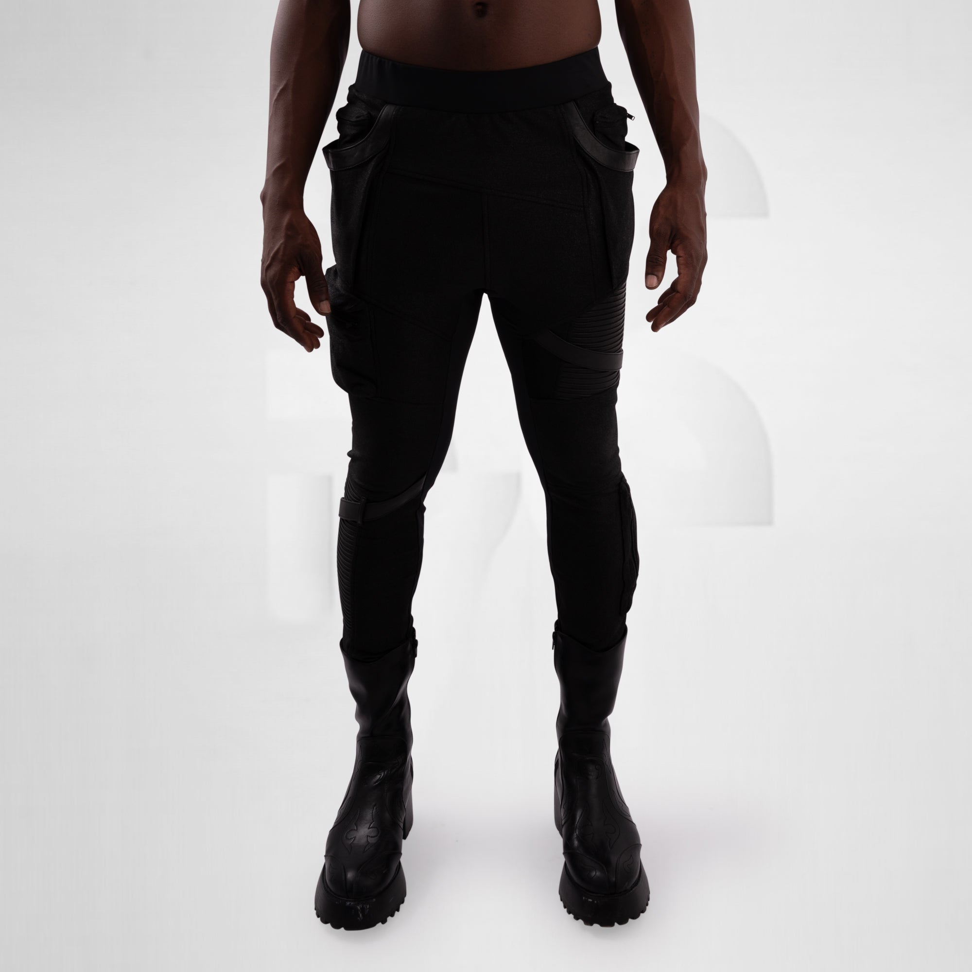 Person wearing black pants and boots on a white background