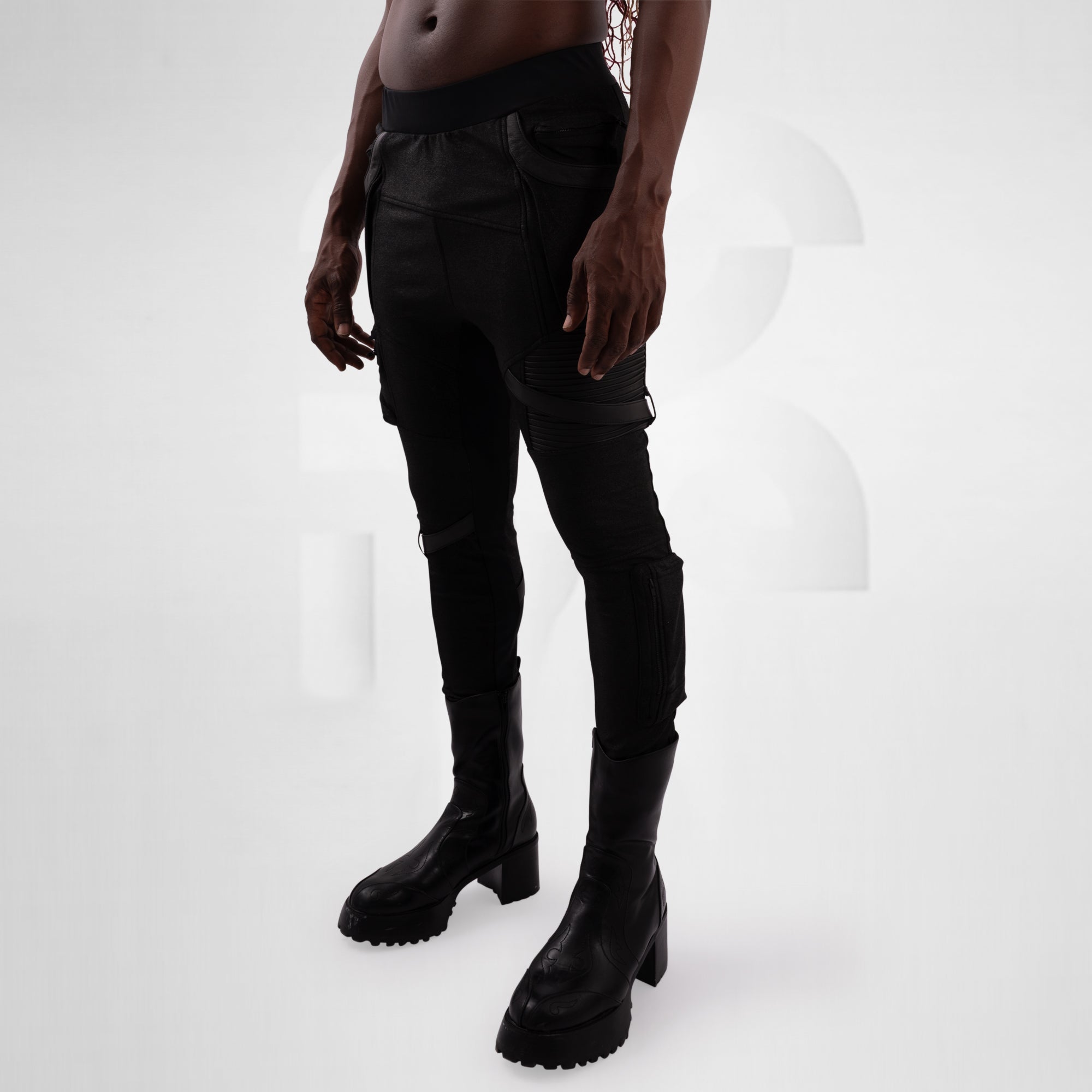 Person wearing black pants and boots on a white background
