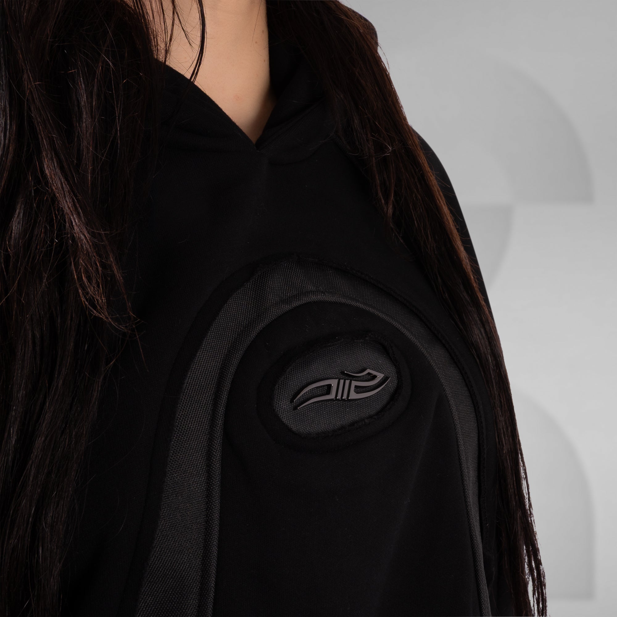 Black garment with a brand logo on a neutral background