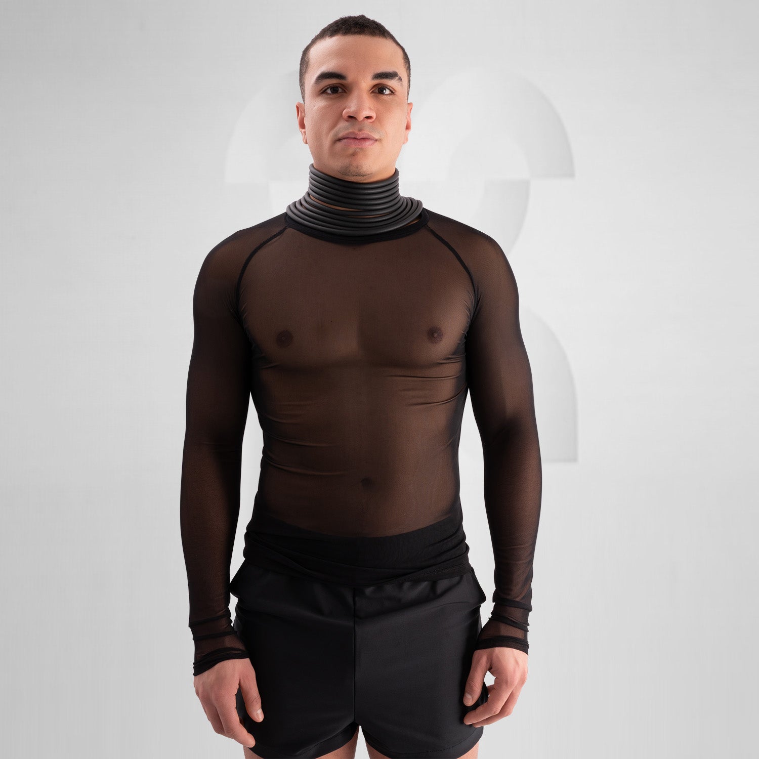 Model wearing a bold, futuristic black sheer long-sleeve top with a high neckline, paired with black cut-out shorts. The look is completed with a statement metallic choker and nipple pasties, creating an edgy, avant-garde aesthetic. Perfect for techno, festival, and alternative fashion