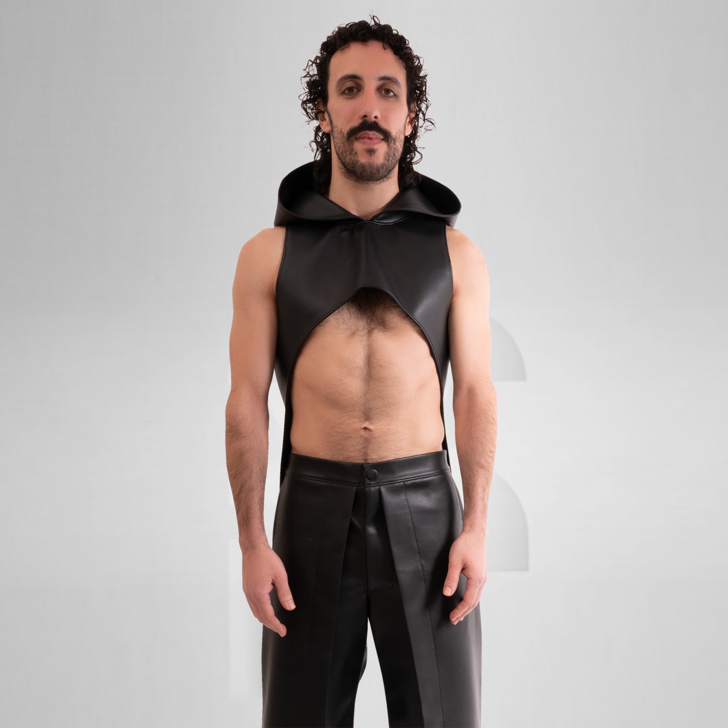 The Vegan Leather Cropped Hoodie by This is Fred features a striking design that combines tribal-inspired elements with a contemporary avant-garde aesthetic. The model showcases this unique piece, which is both bold and eye-catching. Crafted from animal-friendly materials, the hoodie offers comfort and a sense of style that’s perfect for festivals or as an audacious addition to everyday outfits. Its cropped silhouette and distinctive hood create a fashion-forward look that truly makes a statement.