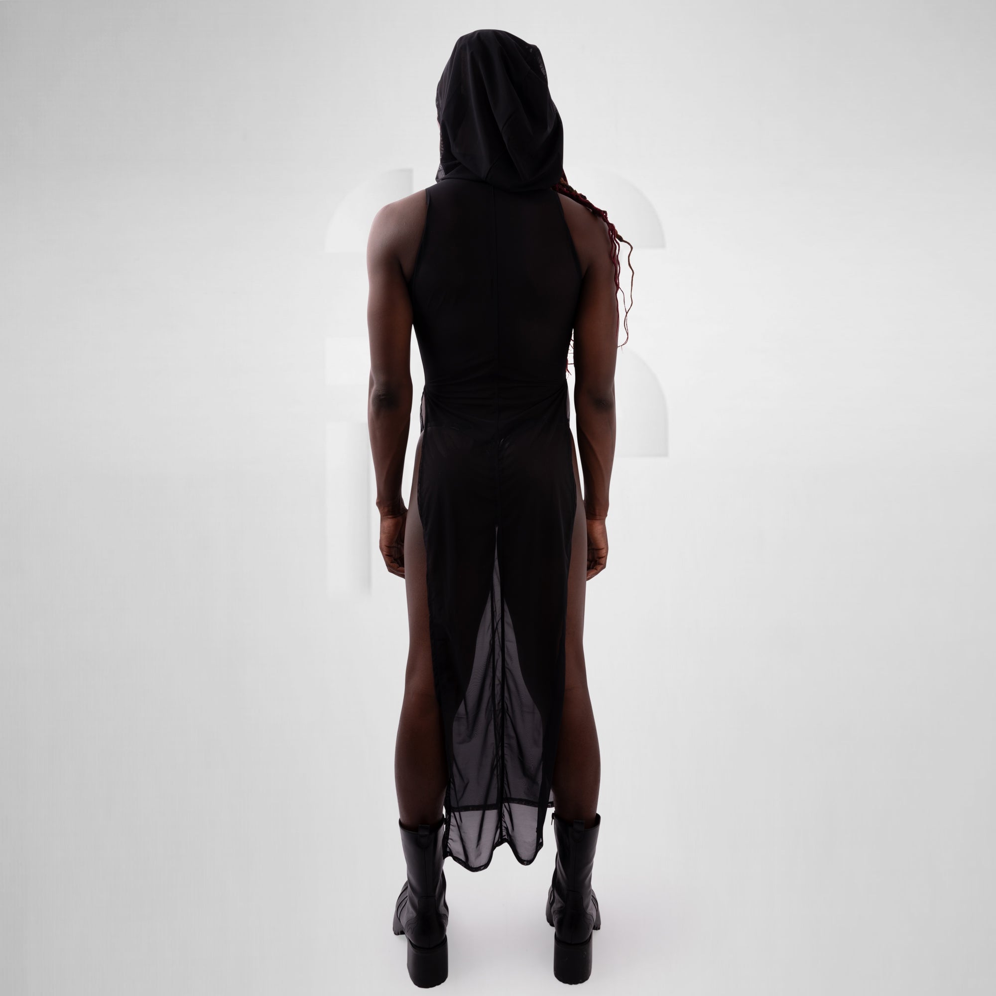 Person wearing a black dress with sheer panels on a white background