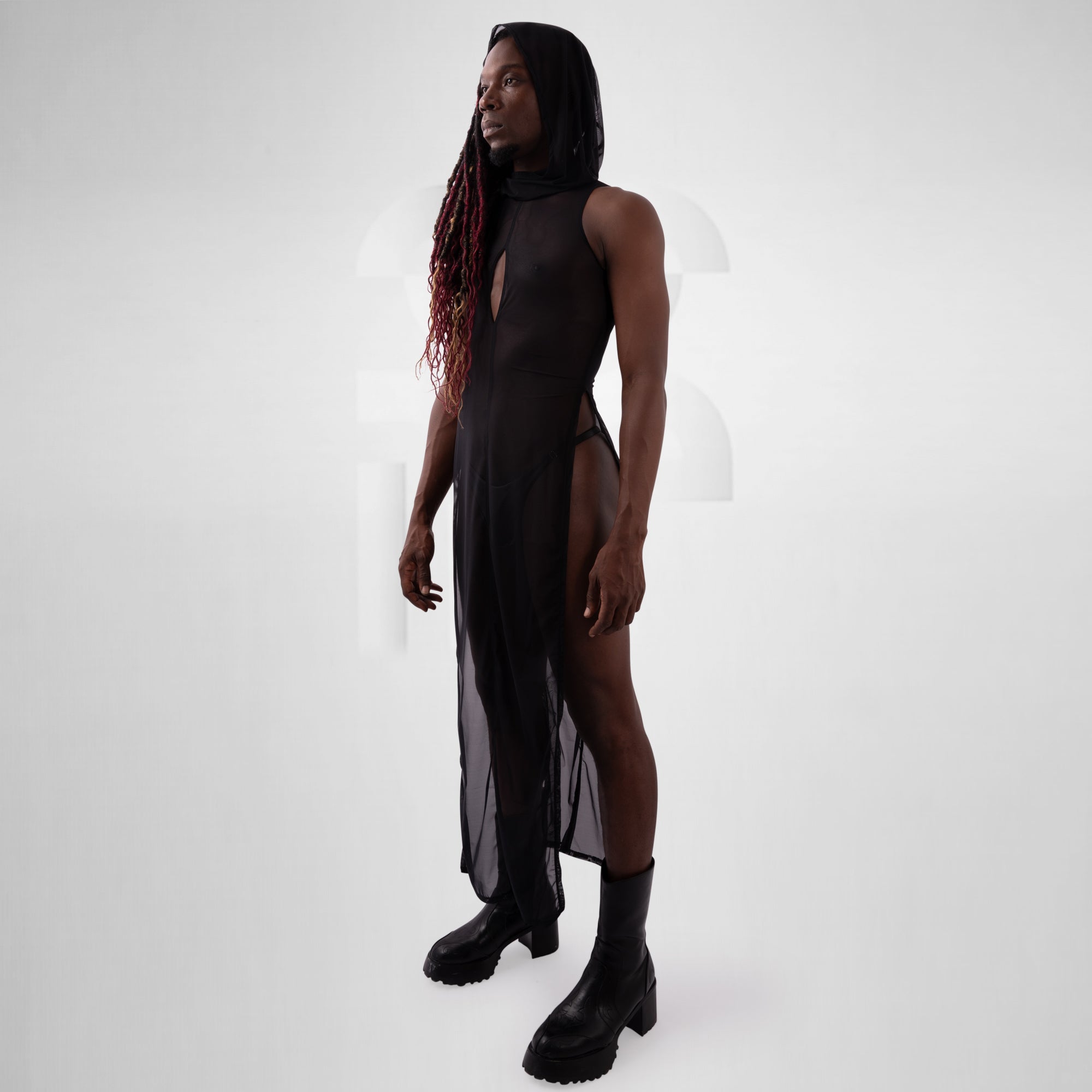 Person wearing a black dress with sheer panels on a white background