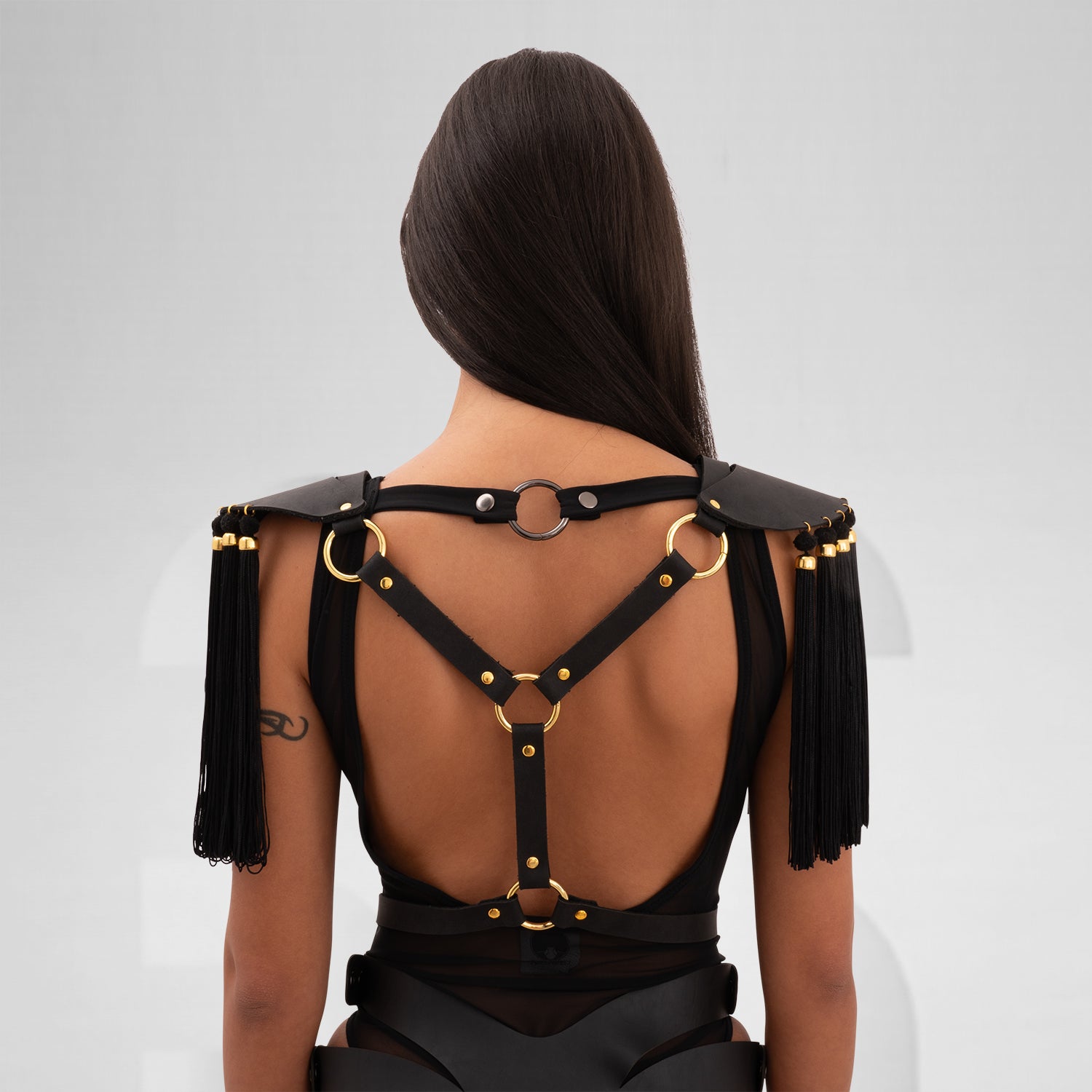 faux leather shoulder harness with flowing tassels and gold bead details, inspired by ancient warriors and celestial aesthetics. Adjustable straps for an empowering, mystical fit.