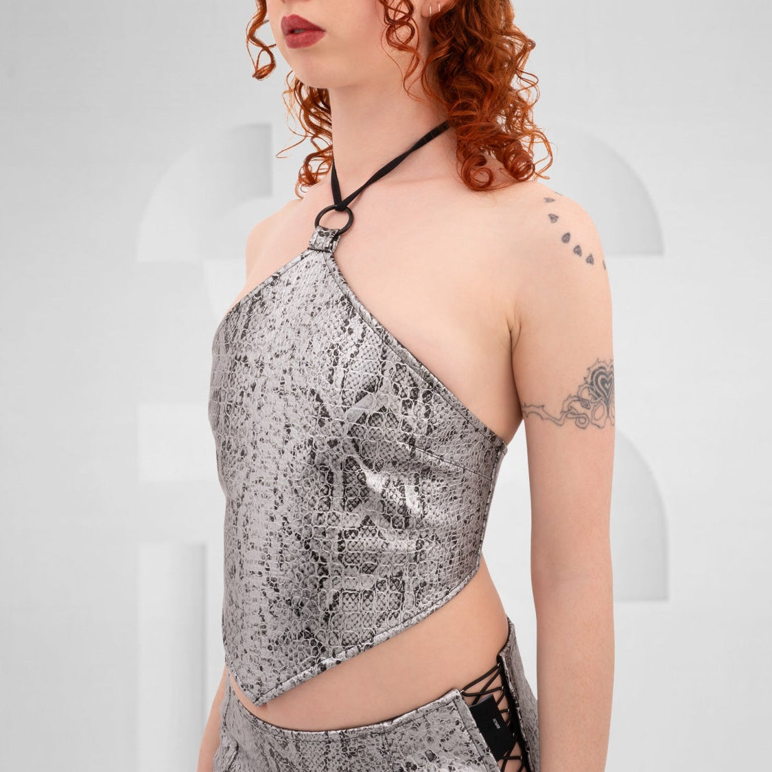Stylish silver PVC snake skin rombo top featuring a lace tightening detail at the back.