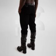 Black jeans with intricate vegan leather laser cut pockets and silver ring accents for a trendy and edgy look.