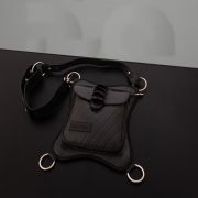 A black vegan leather hip bag with silver ring details, suitable for all occasions.